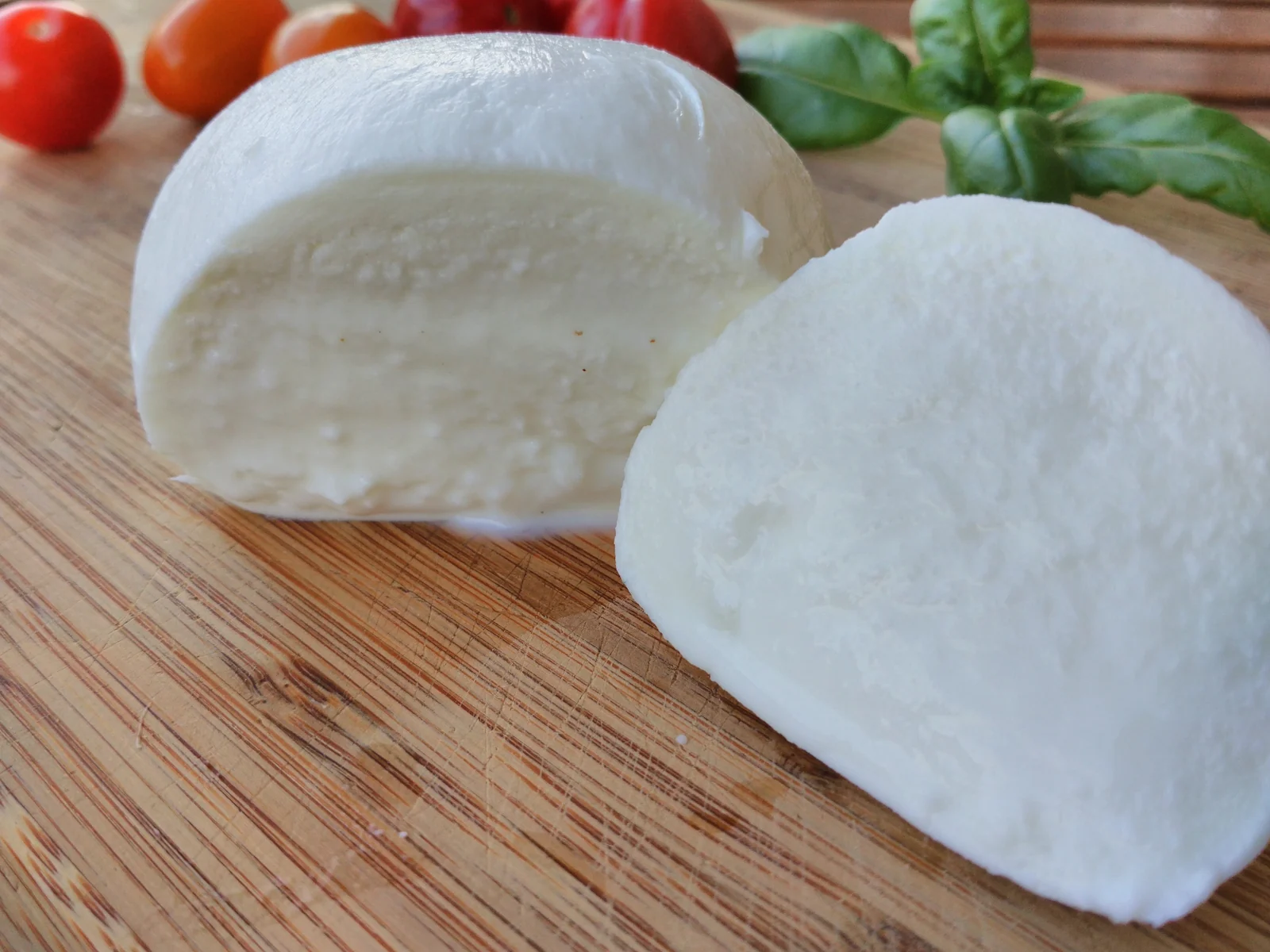 Mozzarella di bufala tagliata, con pomodorini e basilico, fotografia illustrativa